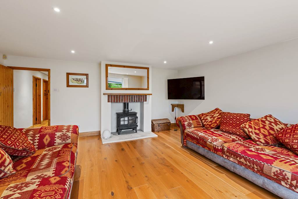 Warm living room with a wood burner and oak flooring