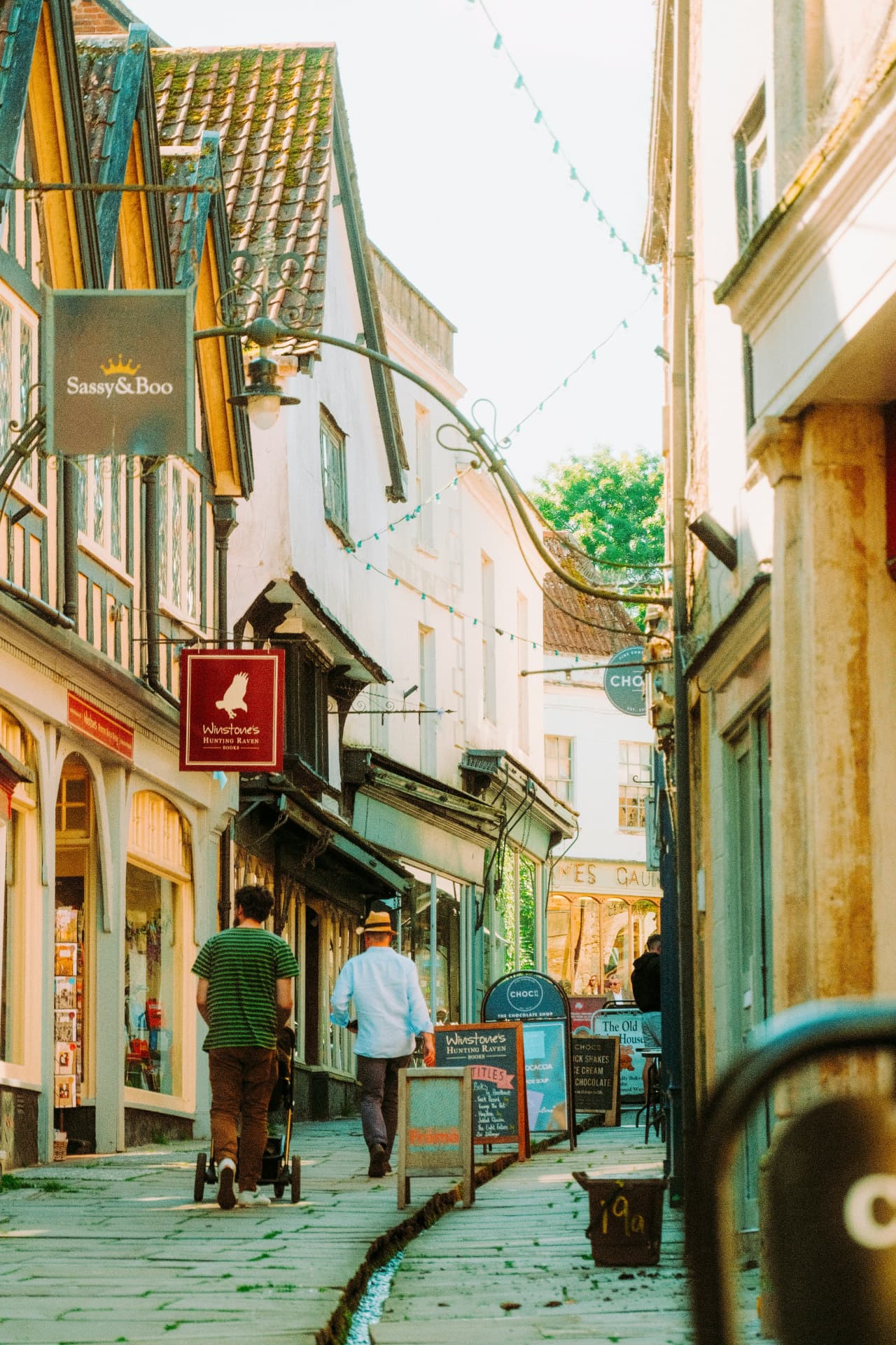 Historic stone buildings on a sunlit street in Frome